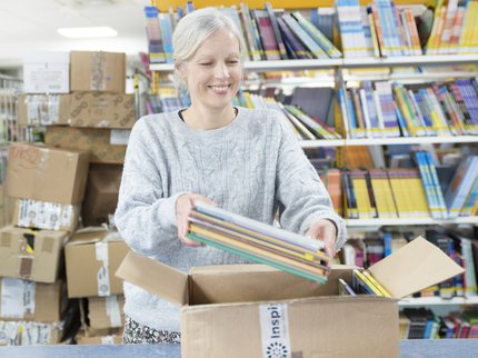 A person takes books out of a box