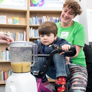 A mother and son using a smoothie bike