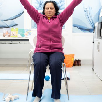 A woman practicing chair yoga