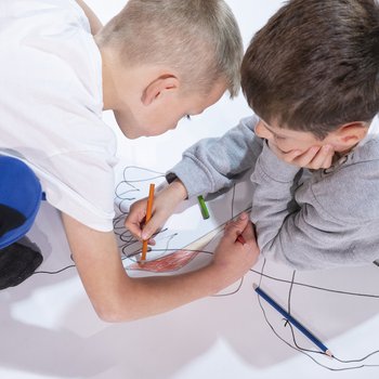 Two school boys drawing together