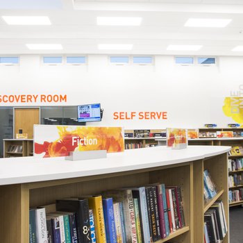View over bookshelves towards self service area in Beeston Library