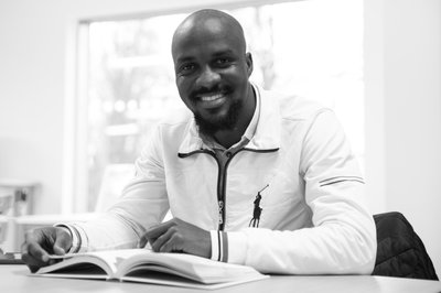 A black and white photograph of a man reading