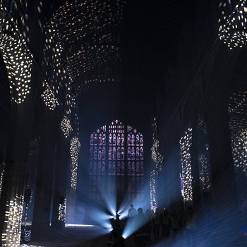 Dark church interior with patches of circular light projections .