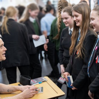 Author dam smith signs books and talks to three pupils