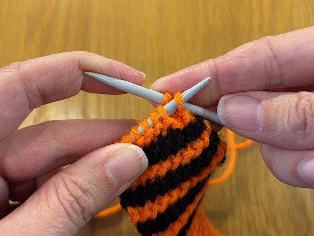 Left knitting needle going into first stitch on right knitting needle