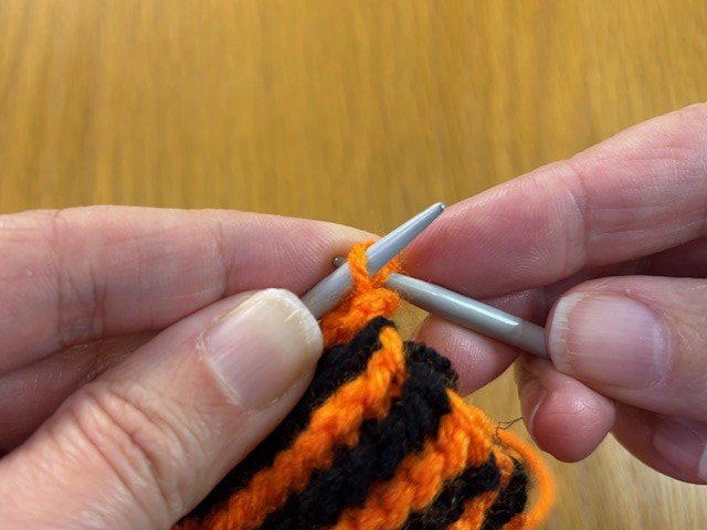 One knitting stitch being brought over another