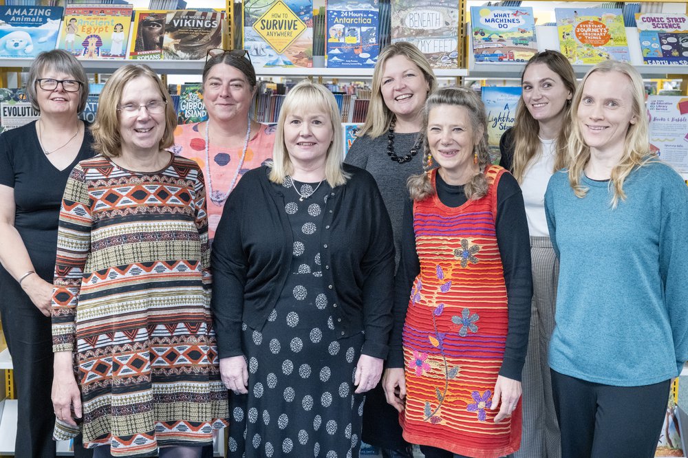A group of women standing in front of book shelves at the ELS offices