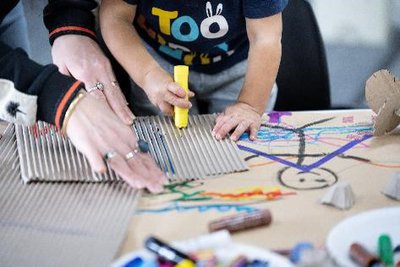 Aerial view of child's paint covered hands making hand prints