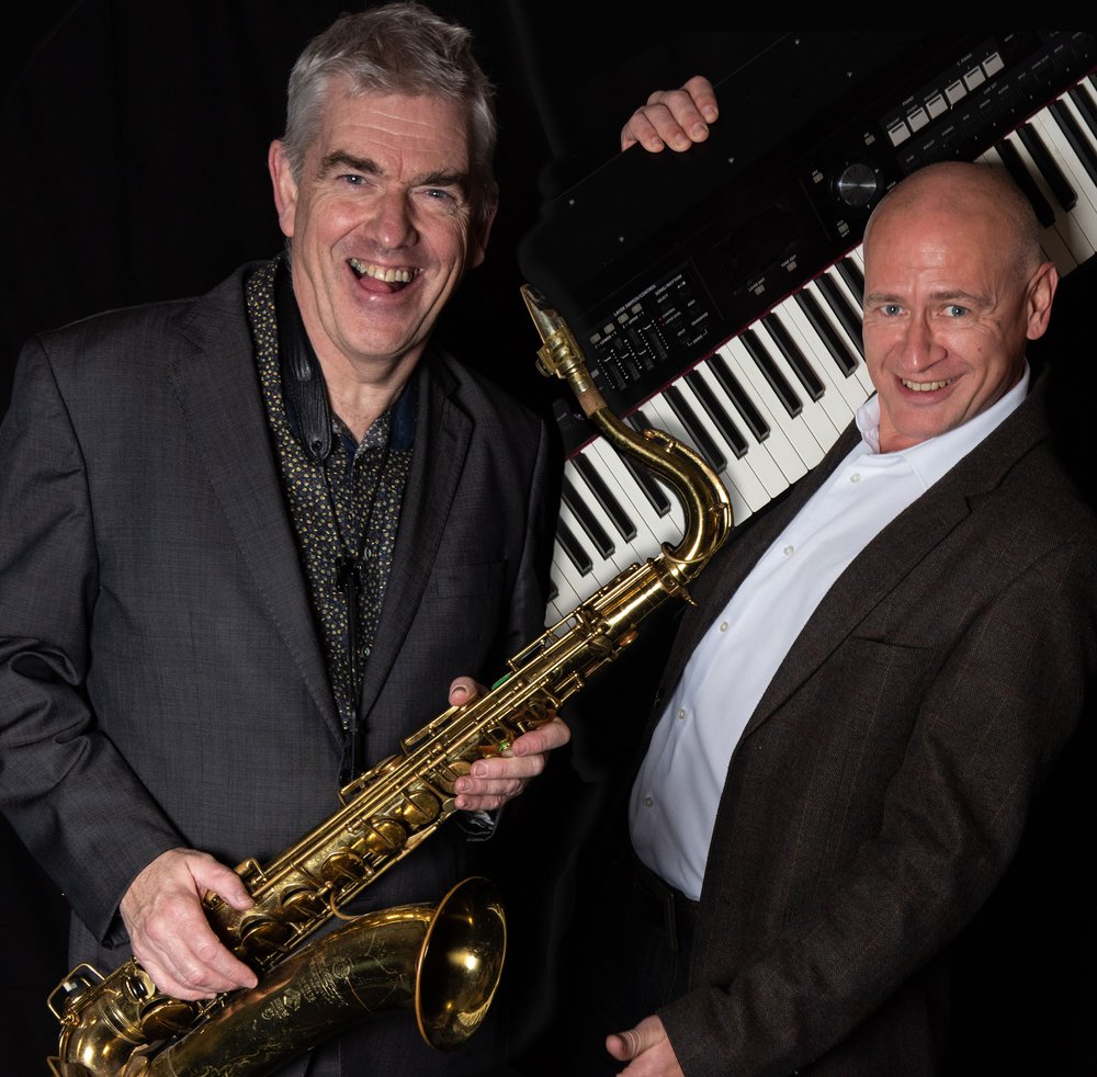 Photo of a saxophonist and a keyboard player, pictured with their instruments