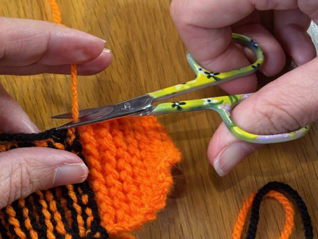 Scissors cutting a piece of yarn