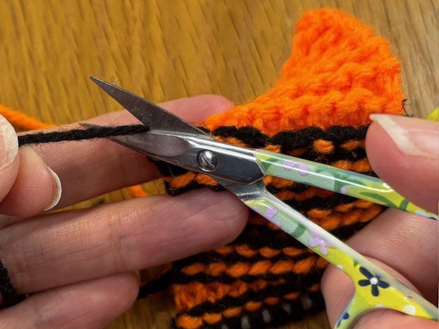 Scissors cutting a piece of yarn