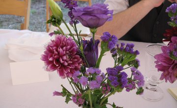 Glass vase with a display of purple flowers and green foliage