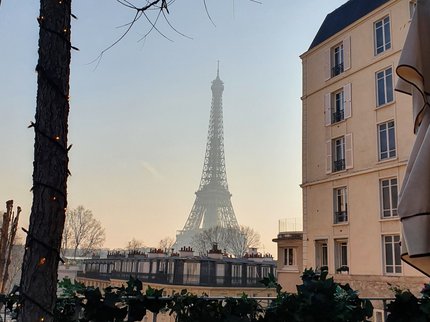 A photograph of a French bistro with the Eiffel Tour in the background.