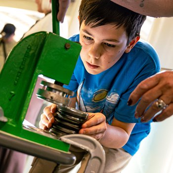 boy using badge making machine