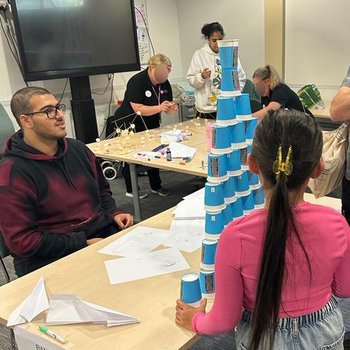 BAME Engineers helping Fun Palace visitors with building challenges using paper cups plus marshmallow and spaghetti towers