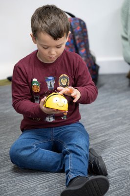 young boy playing with a Bee-Bot