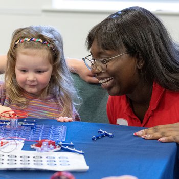 A girl and young woman doing a science activity using snap circuits.