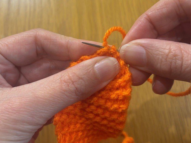 Stitching a piece of knitting, to gold in a gather