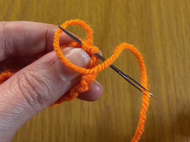 Stitching a gathered section of knitting to hold it in place