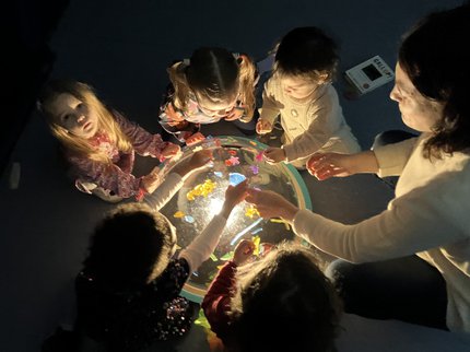 Girls around a dome exploring light and blocks
