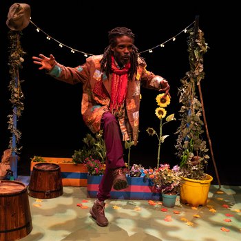 Grandad (Marcus Hercules) strikes a lively pose in the garden with a string of lights behind him.