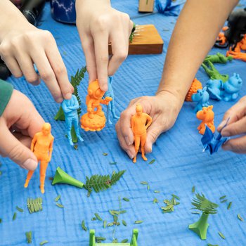 Photo of hands holding 3D printed figures