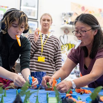 Photo of Storyteller Ling Peng and a member of Spectrum WASP playing kazoos