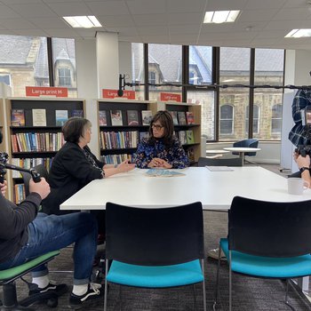 People with cameras sat around a table