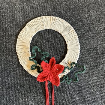 A Christmas wreath made out of wool using Macrame techniques.