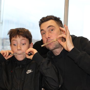 Father and son playing homemade instruments made from lollypop sticks