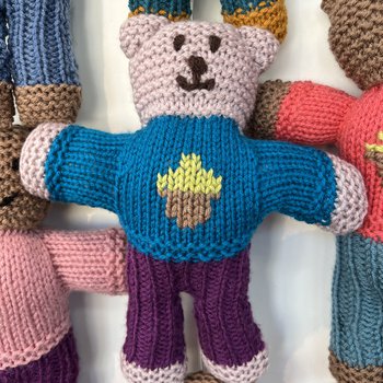 A hand knitted Brave Bear with a blue jumper