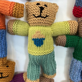 A hand knitted Brave Bear with a green jumper