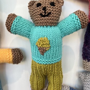 A hand knitted Brave Bear with a light green jumper