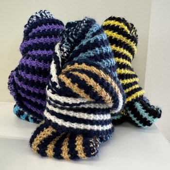 Folded scarves on top of the library shelves