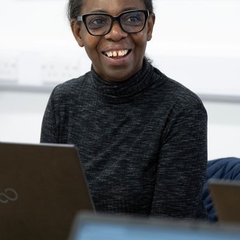 female learner at a laptop smiling