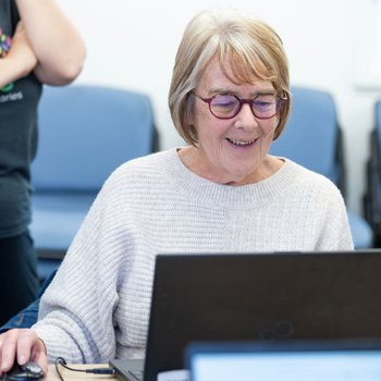 female learner at a laptop smiling