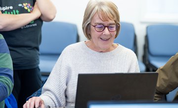 female learner at a laptop smiling