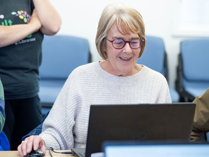 female learner at a laptop smiling