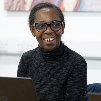 female learner at a laptop smiling