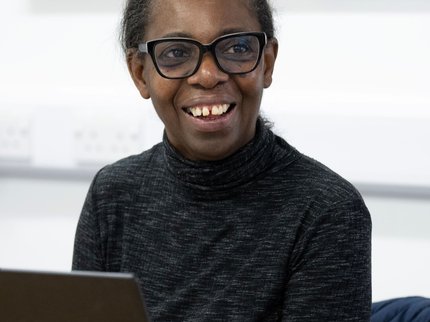 female learner at a laptop smiling