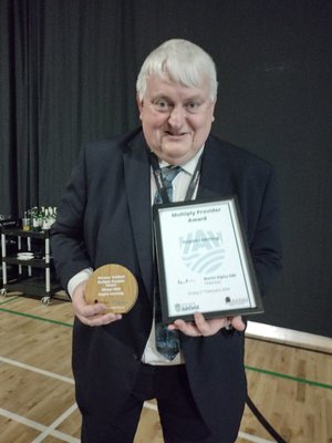 Ian Bond, Inspire Learning Director receives a Kirkby Multiply Award certificate and wooden plaque at the Discovering Ashfield Awards event.