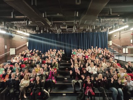 Staff in auditorium holding up 10 fingers
