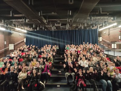 Staff in auditorium holding up 10 fingers