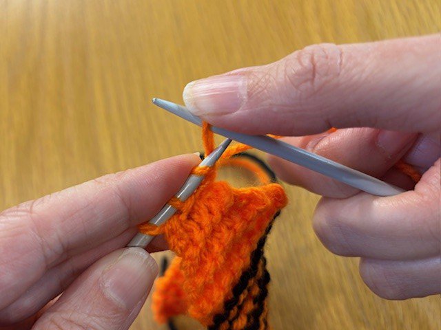 Left-hand knitting needle over stitch on right-hand knitting needle