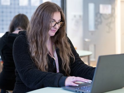Female college student sitting at a laptop