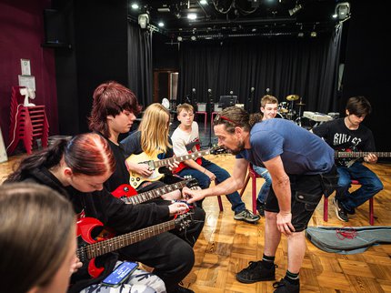 A group of young people playing different musical instuments.