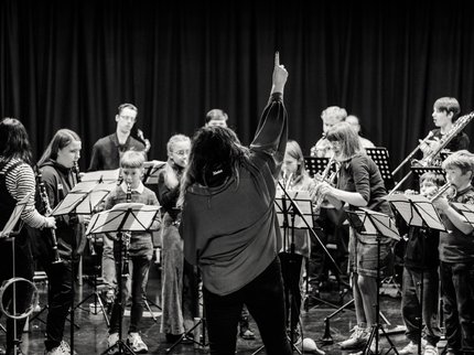 A teacher standing in front of a group of student musicians