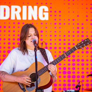 A singer on stage with the word "Dring" on stage in the background