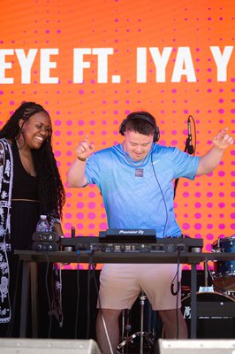 A boy dancing behind DJ equipment