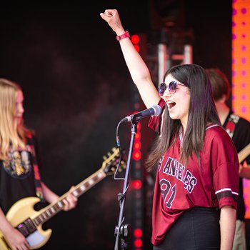 A girl singing raising one arm